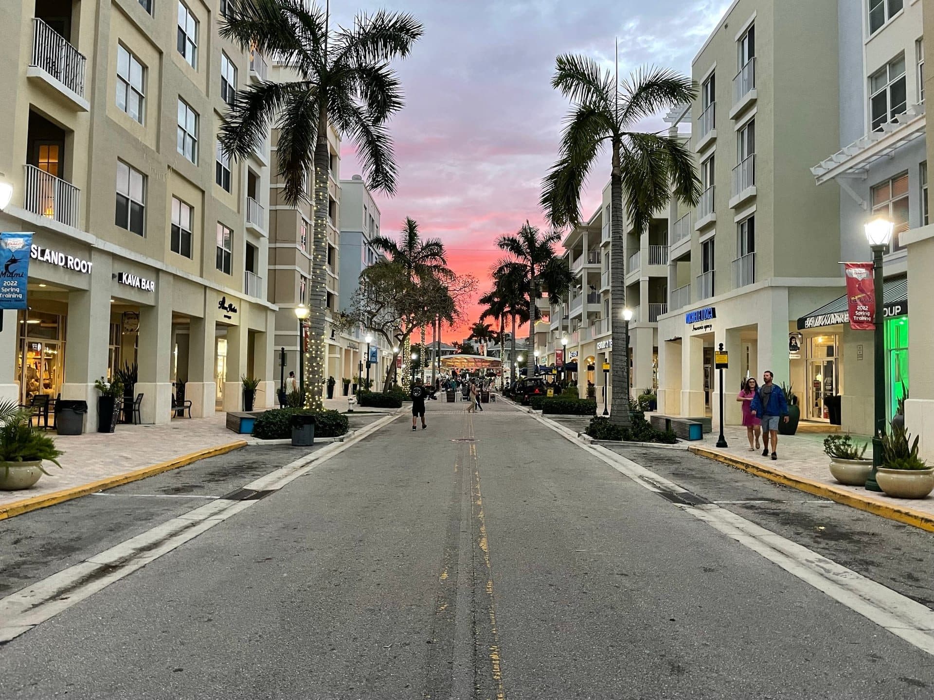 Palm-lined main street of Abacoa Town Center in Jupiter, Florida, at sunset