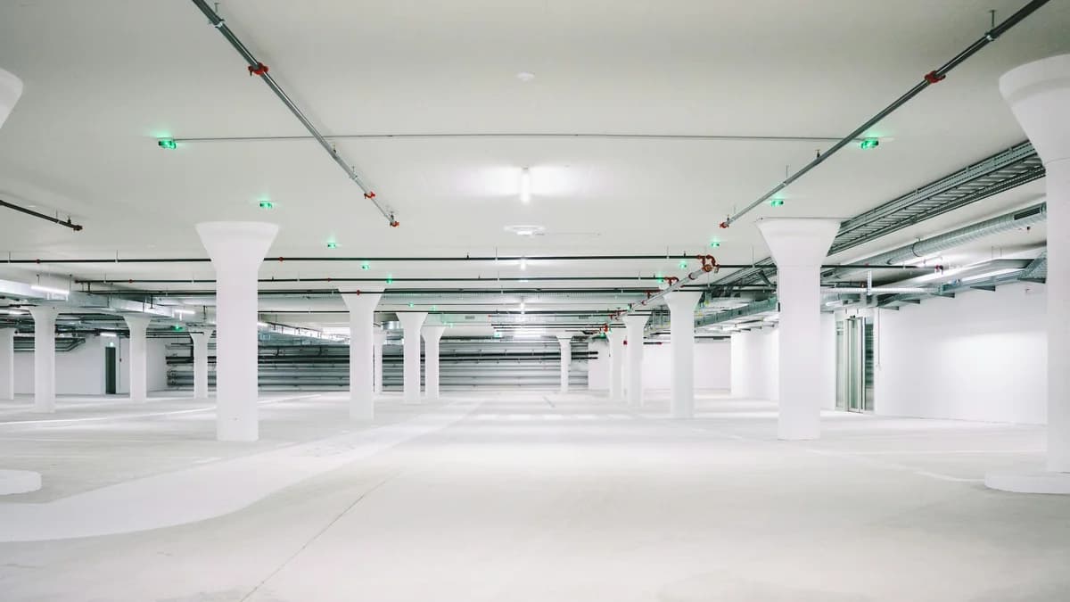 An empty multi-level concrete parking deck with white columns, used here as a representative image