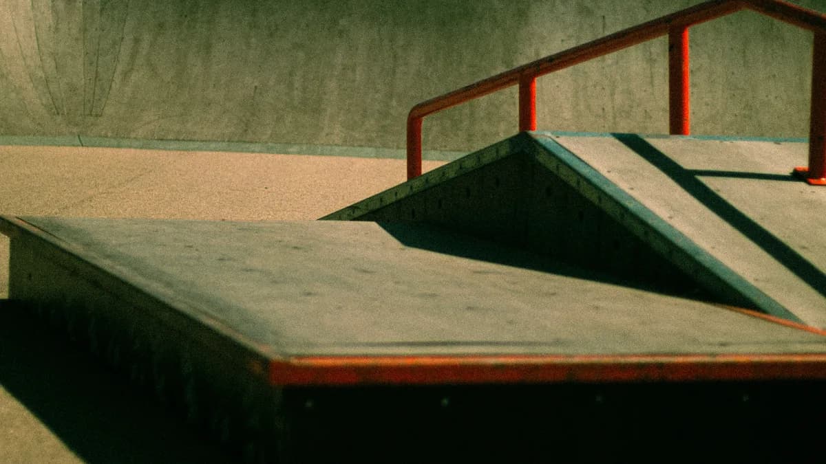 A generic empty skatepark with concrete ramps and rails, used here as a representative image