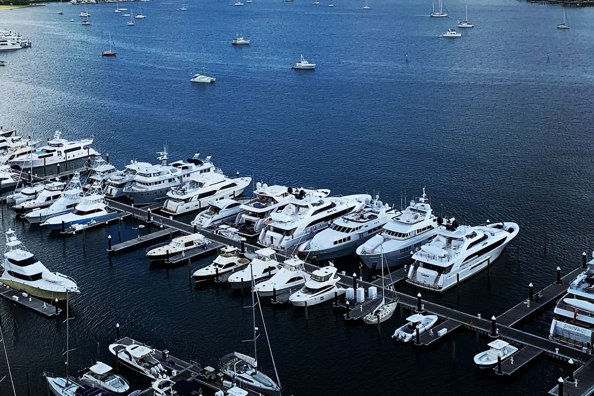 Moored yachts and sport-fishing boats along marina docks seen from above