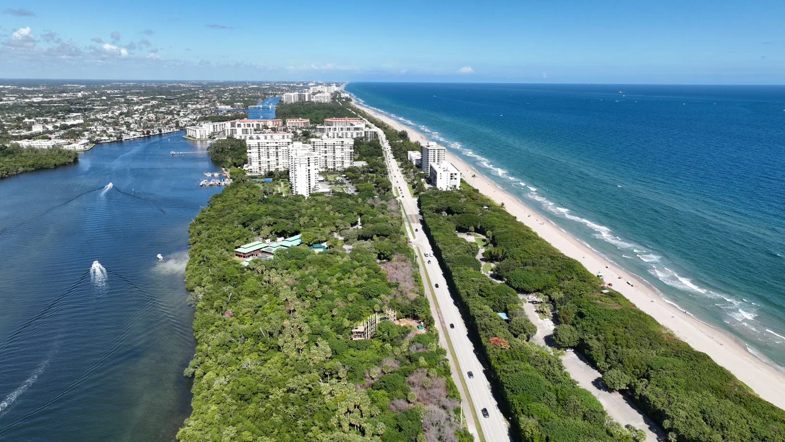 Aerial of barrier island between Intracoastal Waterway and Atlantic Ocean with coastal highway and high-rise condos
