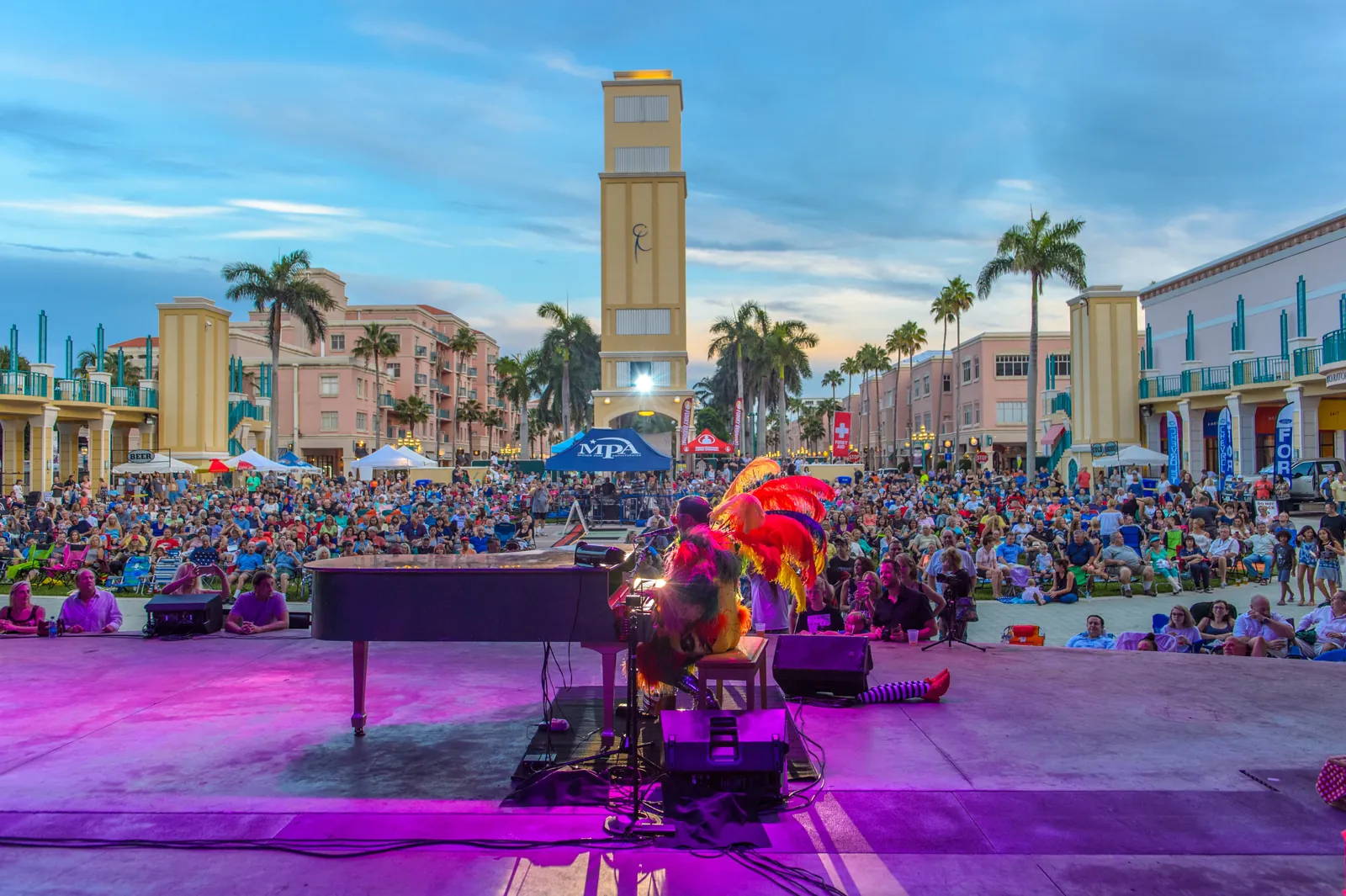 Outdoor concert in a Mediterranean-style town center plaza at dusk