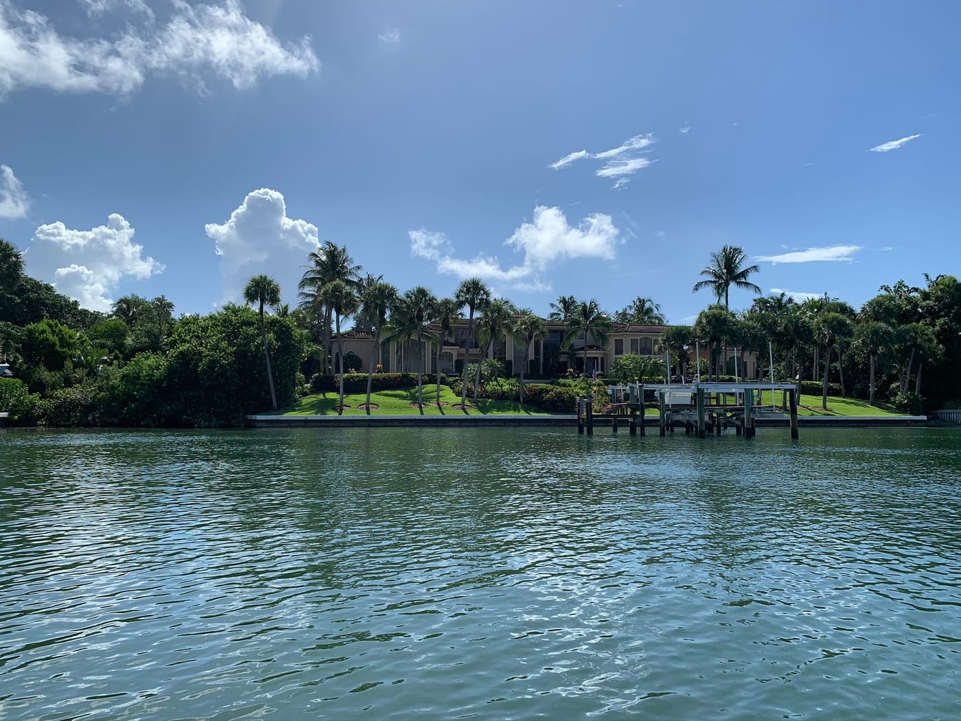 A private dock and boat lift in front of a waterfront home across open water