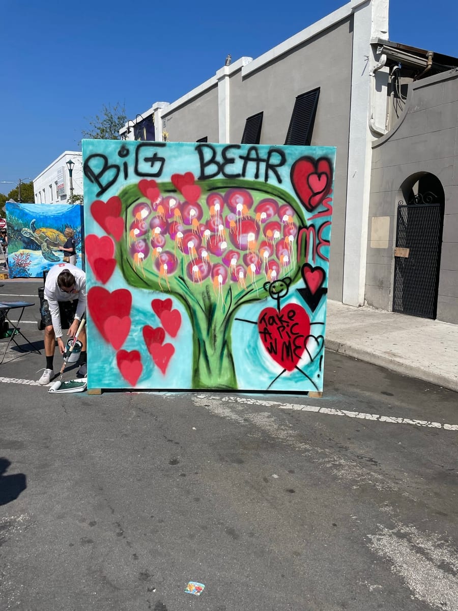 A chalk panel of a heart-shaped tree with the words Big Bear, partly painted