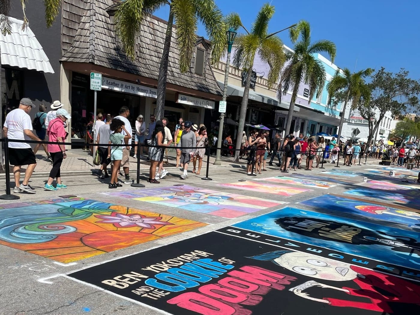 Crowds along Lake Avenue during the Street Painting Festival, chalk panels covering the closed street
