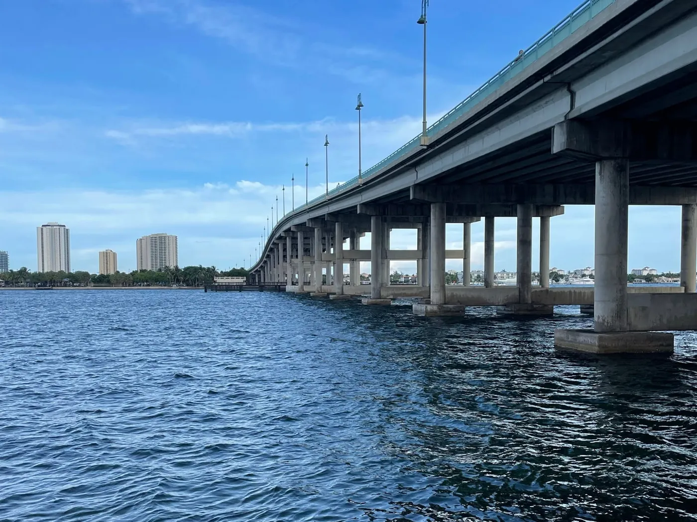 The Blue Heron Bridge crossing the Lake Worth Lagoon on concrete piers, with high-rises in the distance