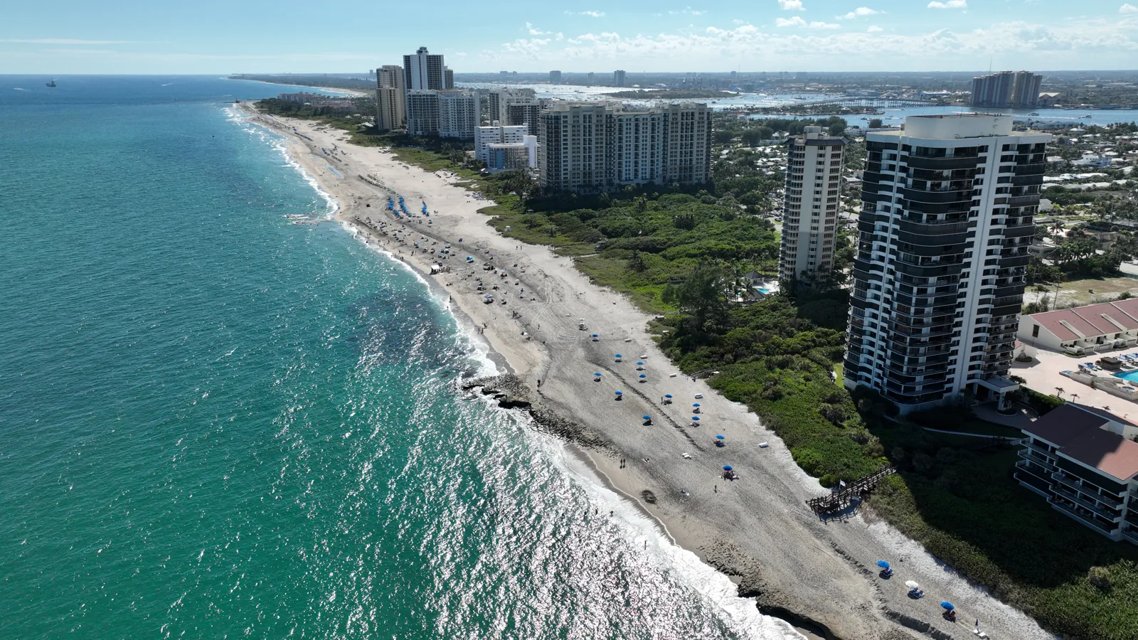 Aerial view of a barrier-island beach with oceanfront high-rise condominium towers