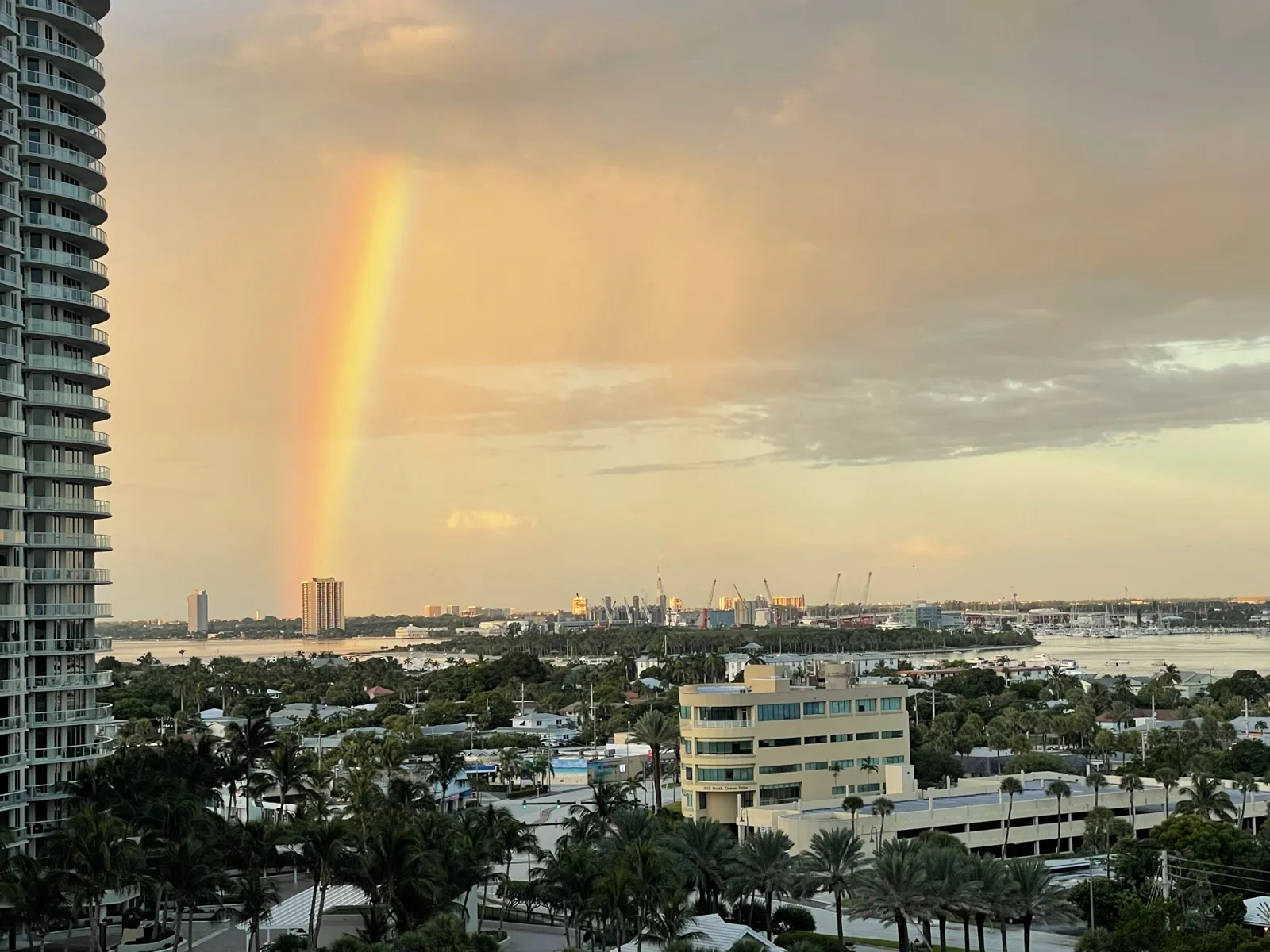 Rainbow at golden hour over intracoastal waterway and port from a high-rise vantage