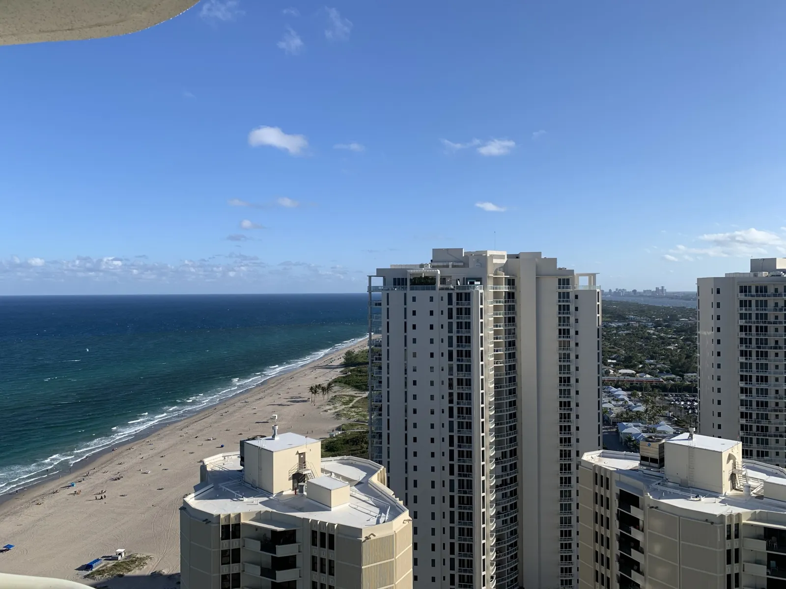 High-floor balcony view of oceanfront condo towers and Atlantic beach