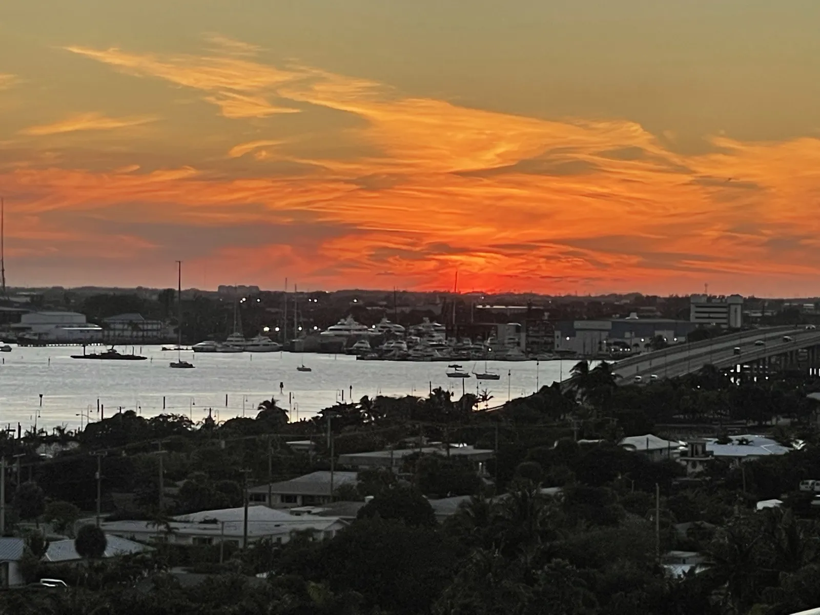 Vivid orange sunset over an intracoastal waterway with marina and bridge