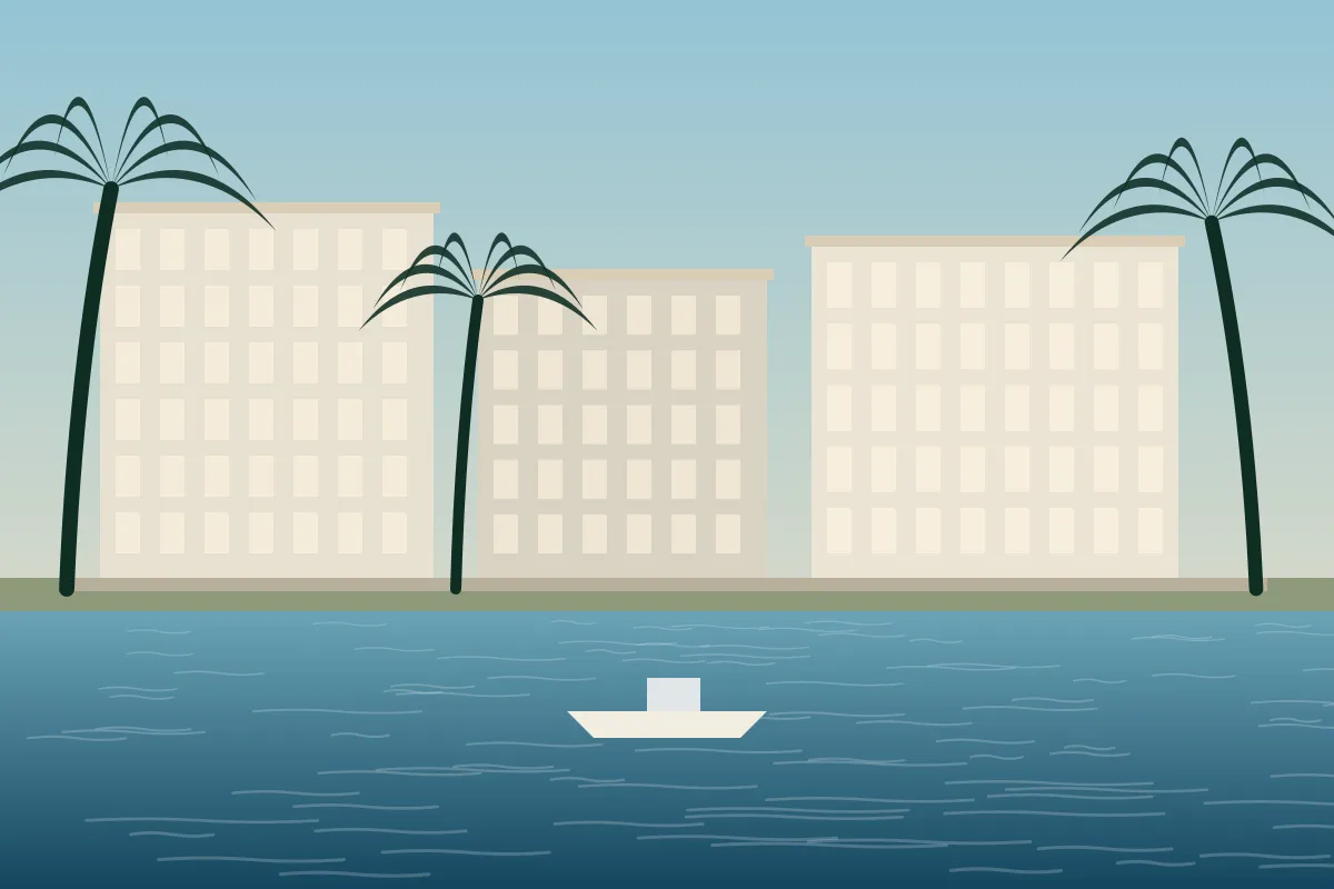 Mid-rise buildings along a waterway with palms and a boat on calm water