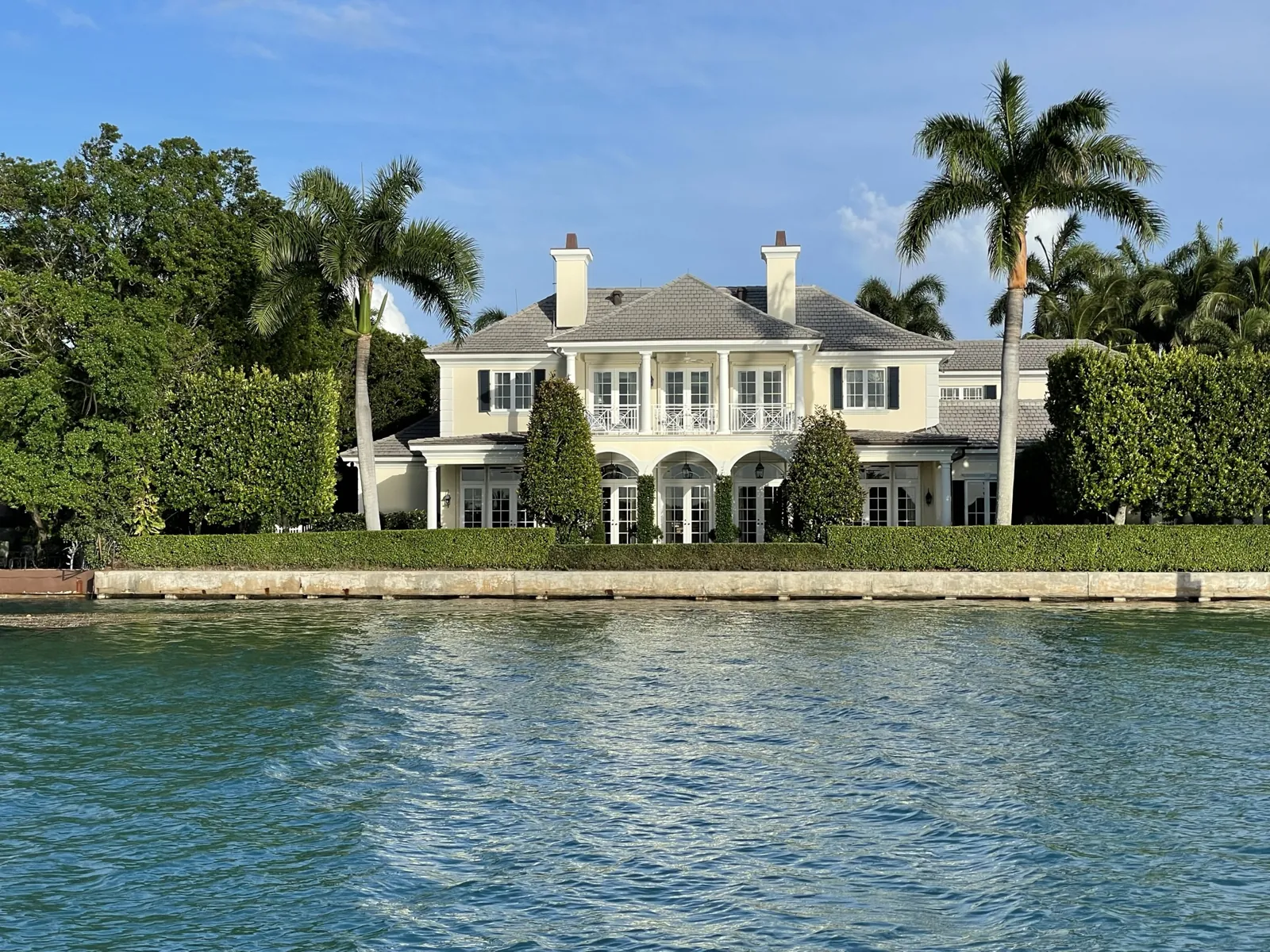 Waterfront two-story estate with Georgian/British West Indies styling, viewed from the water