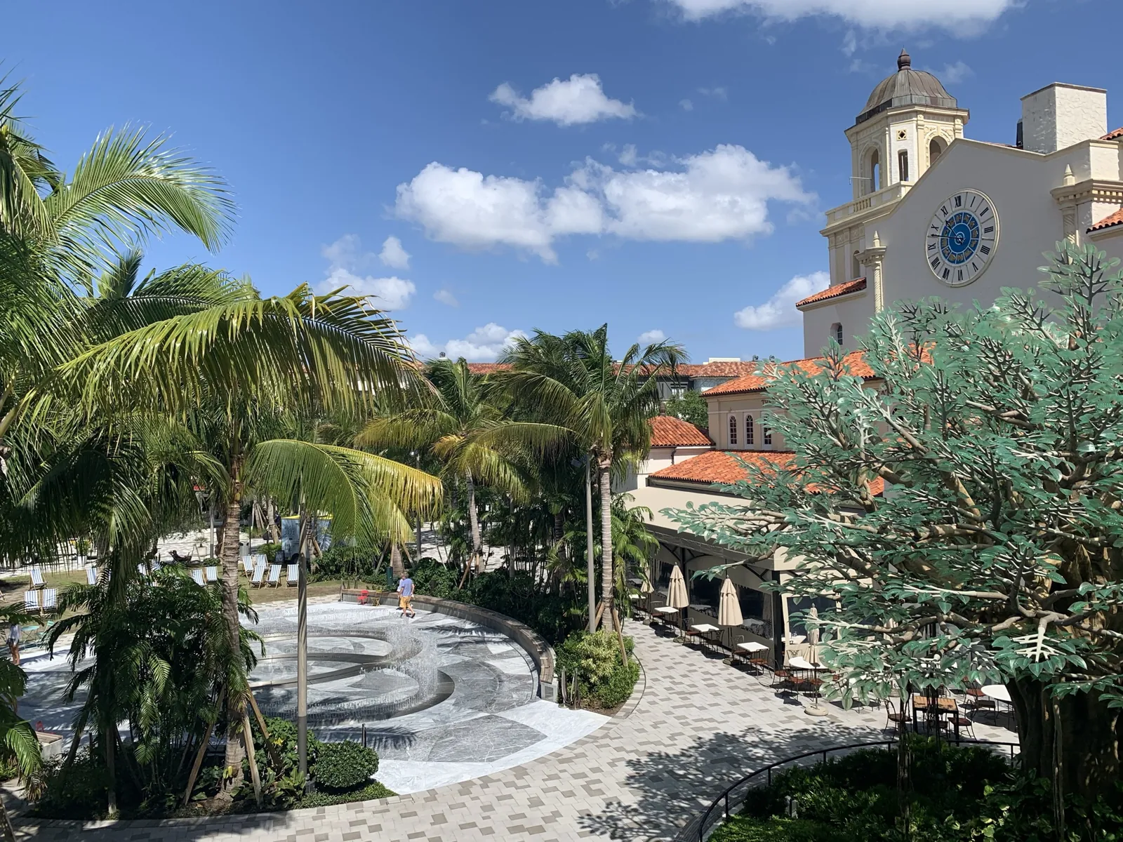 Mediterranean Revival plaza with clock tower, fountain, palms and sculptural tree