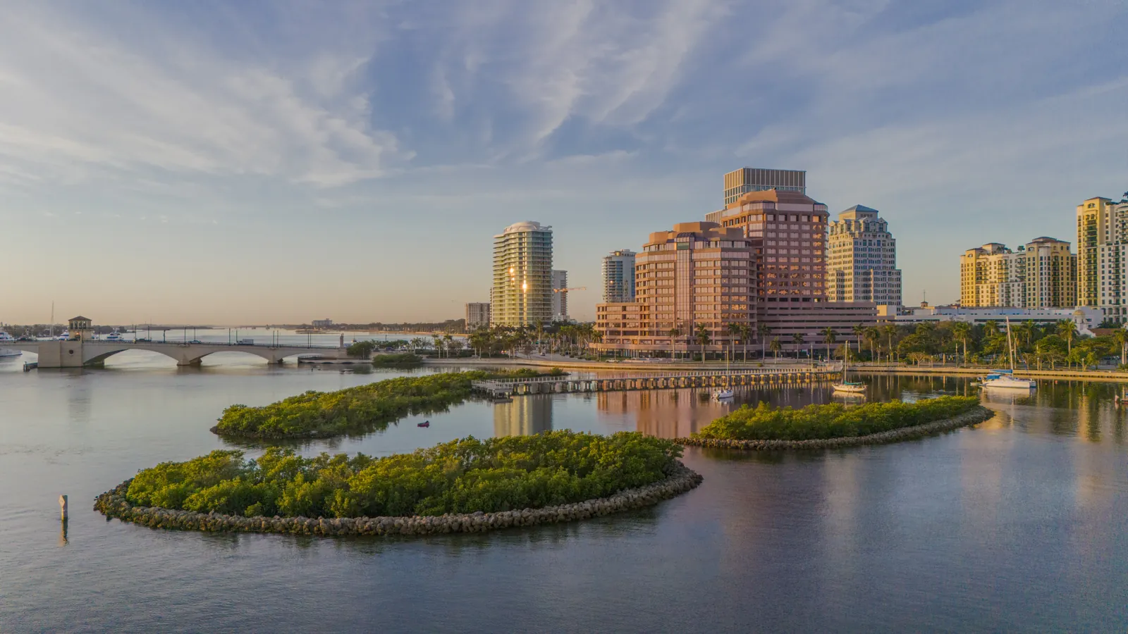 Waterfront skyline at golden hour with mangrove islands and drawbridge