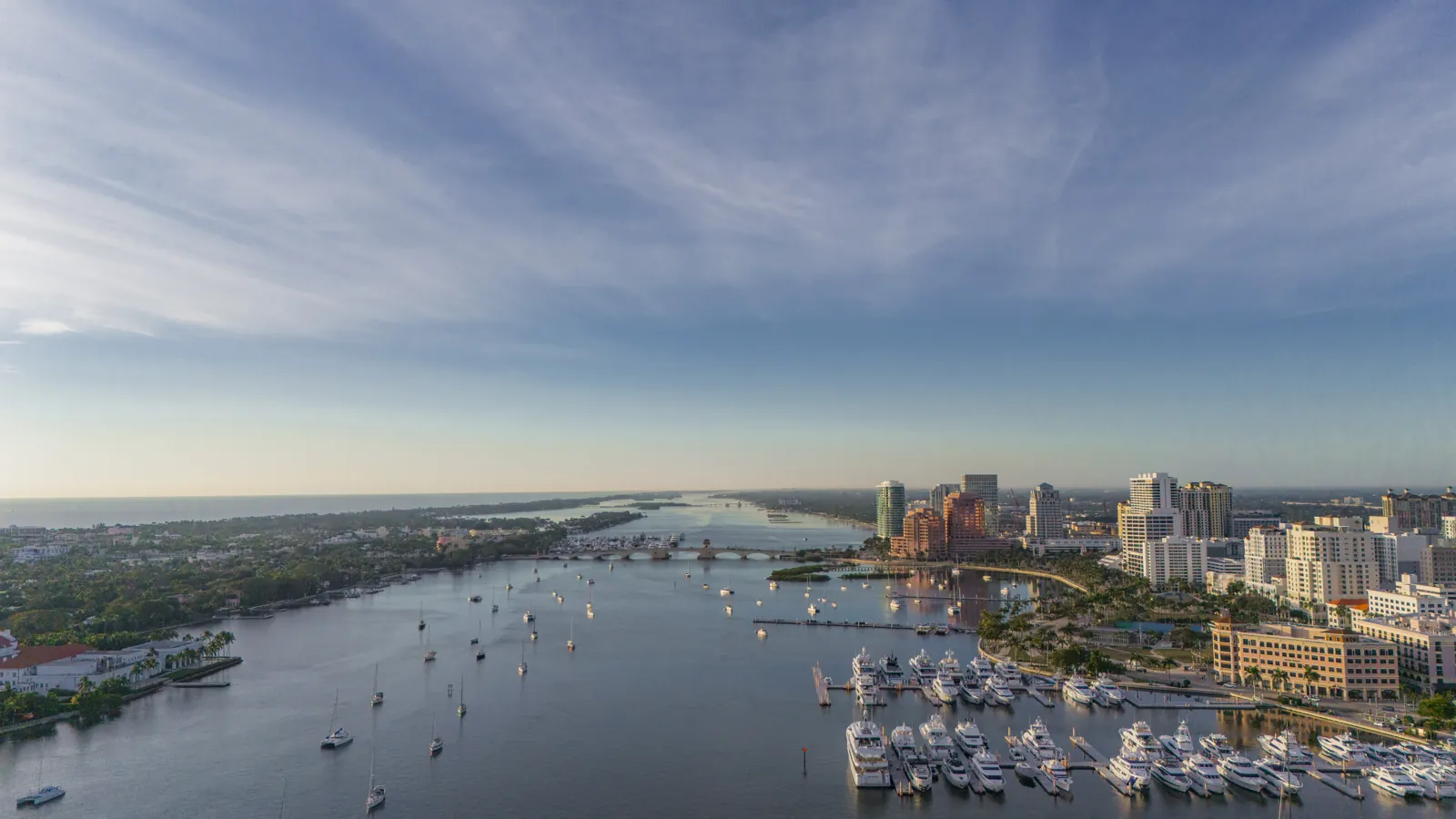 Aerial view of a waterfront downtown skyline, intracoastal waterway and yacht marina at golden hour